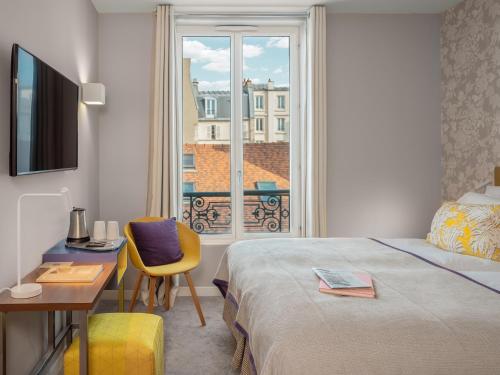 巴黎勒马伊尔酒店的配有一张床、一张书桌和一扇窗户的酒店客房