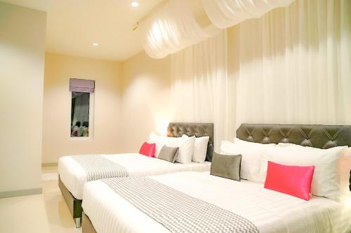 佛丕Temmy Pool Villa, Chaam - Hua Hin的配有白色和红色枕头的客房内的两张床