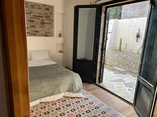贝贾亚Villa la crête的一间卧室设有一张床和一个滑动玻璃门