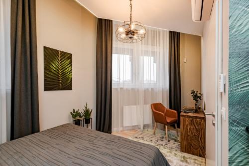 布达佩斯Luxury Tropical Apartment at Budapest的卧室配有床、椅子和窗户。