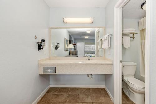 格罗夫城Grove City Travel Inn的一间带水槽、卫生间和镜子的浴室