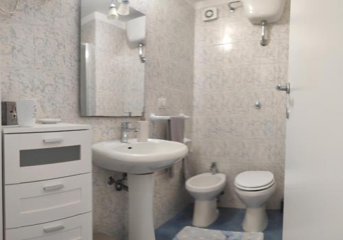 卡利亚里Casa di Eloisa的一间带水槽、卫生间和镜子的浴室