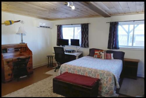 波特兰Guest Space on the Portland Peninsula的一间卧室配有一张床、一张桌子和一台电脑