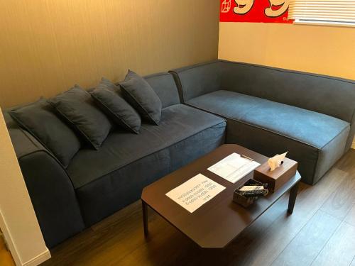 大阪ART HOUSE-アートハウス友家tomoya-的客厅配有蓝色的沙发和桌子
