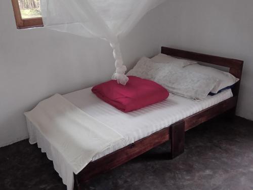 波特尔堡Wakanda cottage kibale的床上有红色枕头