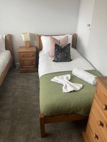 ShenfieldBonningtons - Charming 2 Bed Property In Brentwood的一间卧室配有一张床,上面有两条毛巾