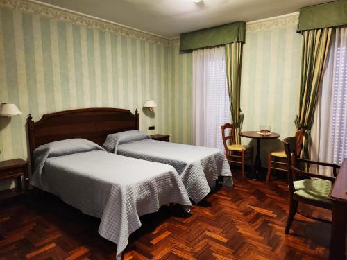波坦察Dimora della via Appia PRETORIA的一间卧室配有两张床和一张桌子及椅子