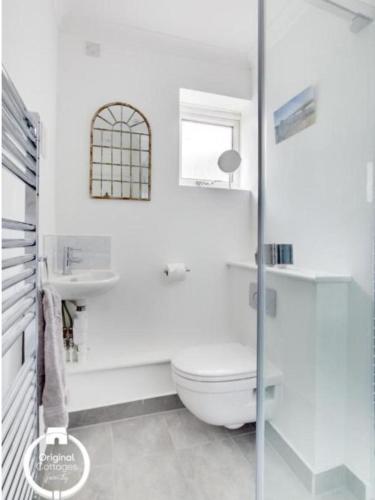 拉伊The Heart of Rye的白色的浴室设有卫生间和窗户。