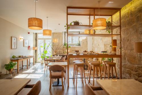 波尔图Memoria Porto FLH Hotels的一间带木桌和凳子的餐厅
