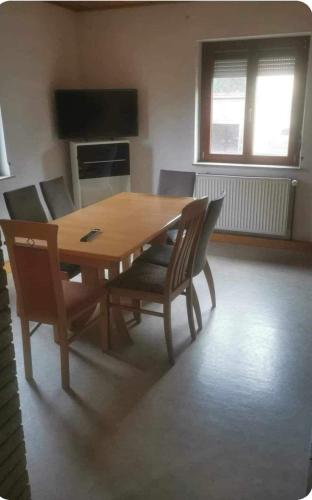 萨森海姆Monteurzimmer rasic的客厅配有一张木桌和椅子