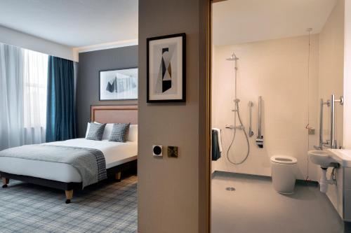 爱丁堡Leonardo Royal Hotel Edinburgh的一间卧室设有一张床和一间浴室。