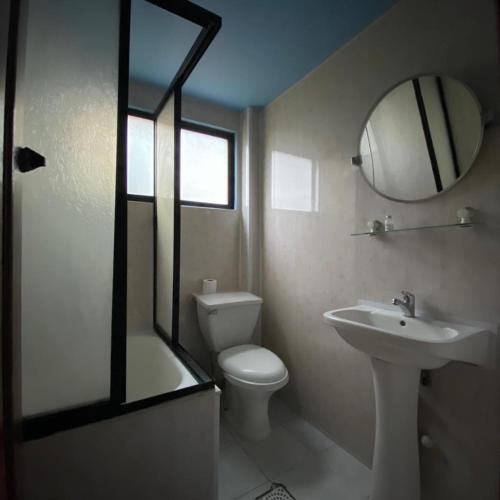 波韦尼尔Hotel Yagan Porvenir的一间带卫生间、水槽和镜子的浴室