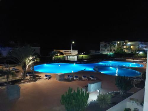 圣米格尔德阿沃纳Sunny Suite的夜间大型游泳池,灯光照亮