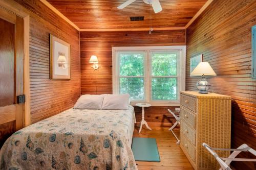 富丽海滩Folly Reclaimed的一间带木墙的卧室和一张位于客房内的床