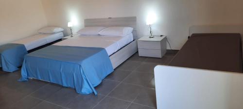 比亚恩科Villaggio Jonio Blu的酒店客房,设有两张床和两张桌子