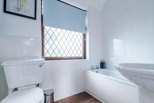 布莱克浦Cosy 2 Bedroom house-Short drive from Blackpool Pleasure Beach的白色的浴室设有浴缸和水槽。