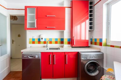 加的斯Martinez by Cadiz Time的一间带红色橱柜和洗衣机的厨房