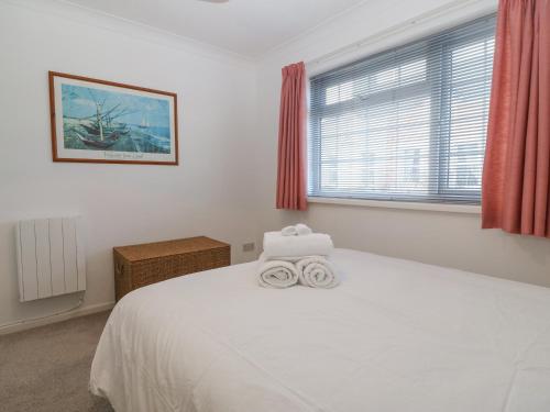 塞米斯湾Riverview Apartment的卧室配有白色的床和2条毛巾