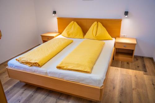 雷西亚Residence Montana的一张带黄色床单和两个黄色枕头的床