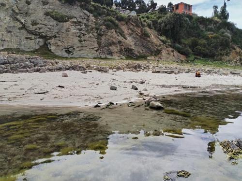 Comunidad ChallapampaECO CABAÑA INTIWAT'A的一片拥有岩石、水和山脉的海滩