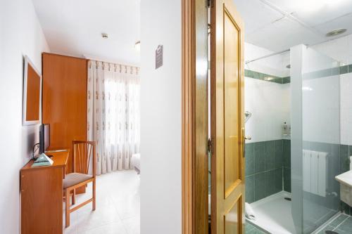 托罗Hotel Alda Ciudad de Toro的带淋浴的浴室和玻璃门