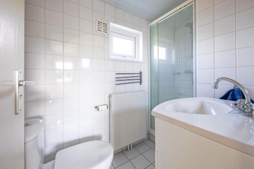 德科克斯多普Chalet de Slufter Texel的白色的浴室设有水槽和卫生间。