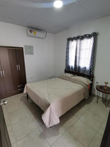 Apartamento full en David, Chiriquí.的一间卧室设有一张床、一个窗口和一张桌子