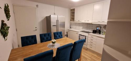 马尔默Central Peaceful Villa, Malmö的厨房配有木桌和蓝色椅子