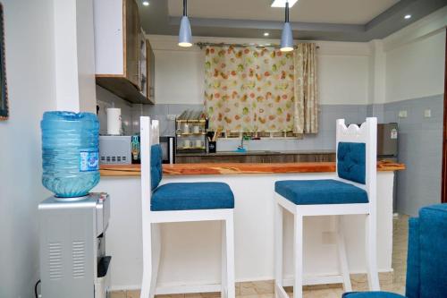 纳纽基Olivet Homes的厨房配有2把蓝色椅子和台面