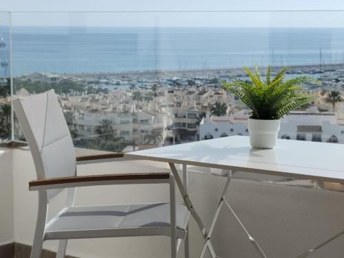多列毛利诺斯Apartamento privado en Hotel Sol Aloha的白色桌子和椅子,上面有植物