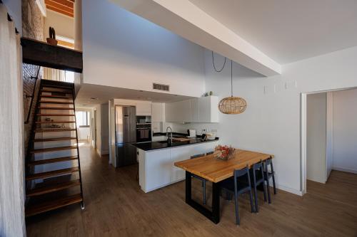 蒙特加特Atico Duplex Playa Area Barcelona con SPA exterior的厨房以及带木桌的用餐室。