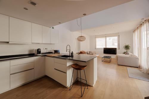 蒙特加特Atico Duplex Playa Area Barcelona con SPA exterior的一间厨房,配有白色橱柜和厨房岛