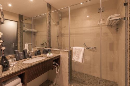艾因苏赫纳Stella Di Mare Grand Hotel的一间带水槽和玻璃淋浴的浴室