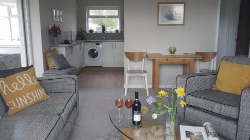 佩文西Harbour cottage sleeps 4 nr Marina Eastbourne的客厅配有2张沙发和带葡萄酒瓶的桌子