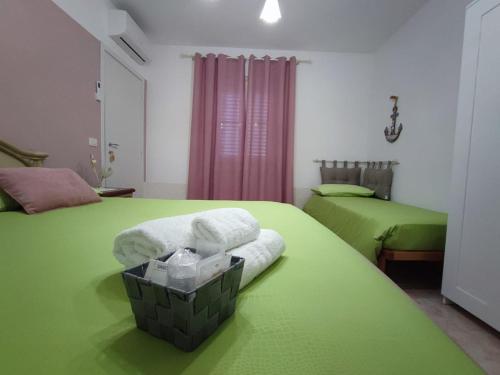 圣欧费米亚拉默齐亚Casetta GGG的一间设有两张床和一篮毛巾的房间