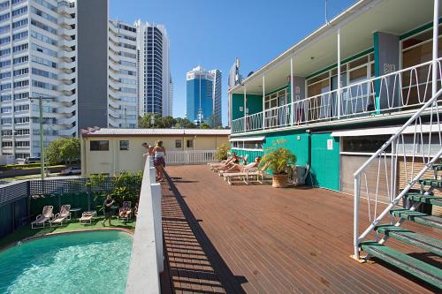 黄金海岸Backpackers In Paradise 18-35 Hostel的一座带游泳池甲板的建筑