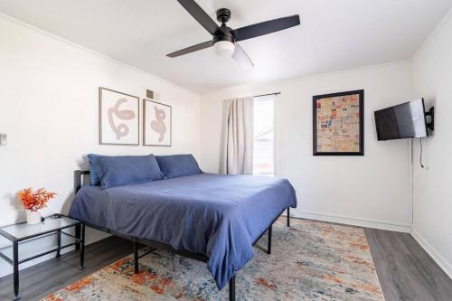 夏洛特4 Bedroom Bungalow - 5 min to Uptown Charlotte的一间卧室配有蓝色的床和吊扇