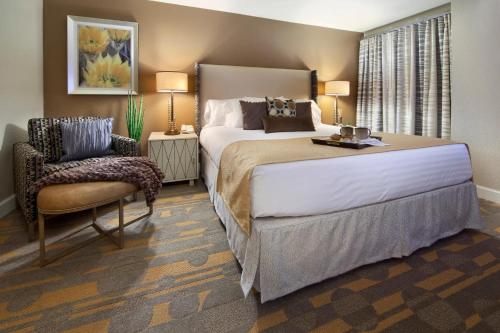 拉斯维加斯Holiday Inn Club Vacations at Desert Club Resorts的一间卧室配有一张大床和一把椅子