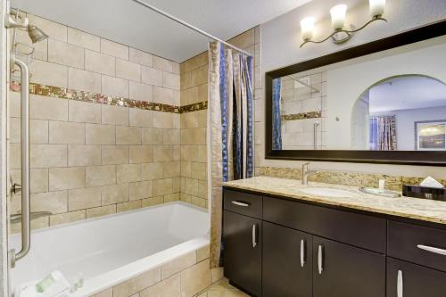 拉斯维加斯Holiday Inn Club Vacations at Desert Club Resorts的带浴缸、水槽和镜子的浴室