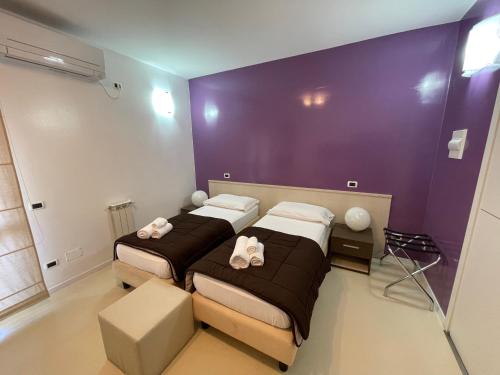 卡利亚里埃利亚的住宿加早餐酒店的紫色墙壁客房的两张床