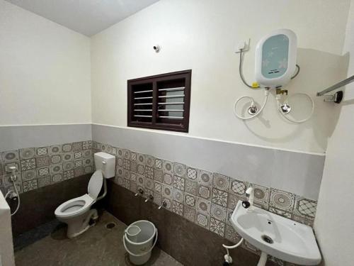 AntarasanteArasu Homestay的一间带水槽和卫生间的浴室以及窗户。