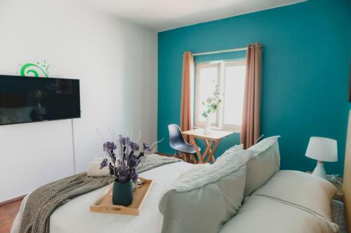 利马Miraflores Private Rooms - Guest House - Cocina Compartida - Terraza的一间卧室配有白色的沙发和蓝色的墙壁