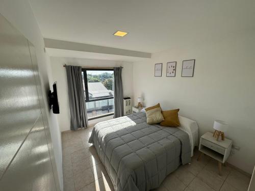内乌肯Solar Suites的一间卧室设有一张床和一个窗口