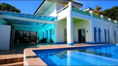BolinaoCouple room in Final Destination Resort的一座房子前面设有游泳池