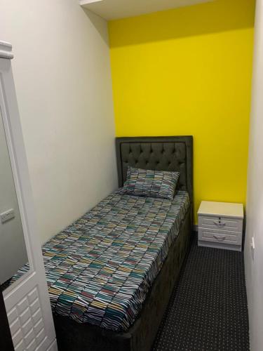 迪拜Paz Holiday Luxurious Space的一间卧室设有一张床和黄色的墙壁