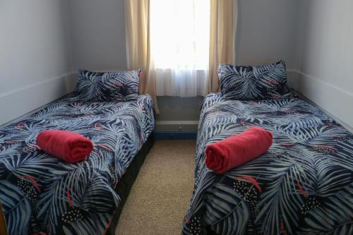 BlackballFormerly the Blackball Hilton的客房内的两张床和红色枕头