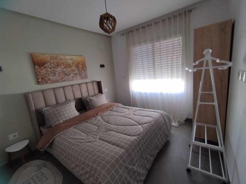 Boumhel El BassatineCoquette Appartement的一间卧室设有一张床和梯子