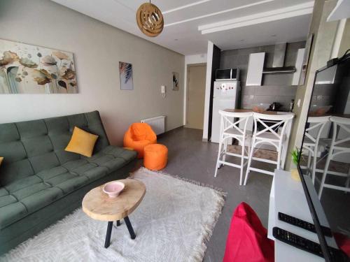 Boumhel El BassatineCoquette Appartement的客厅配有绿色沙发和桌子