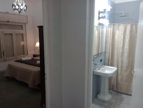 罗萨里奥La Dorada con cochera techada的一间带水槽和卫生间的浴室以及一张床