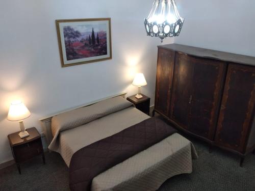 罗萨里奥La Dorada con cochera techada的一间卧室配有一张床、梳妆台和两盏灯。
